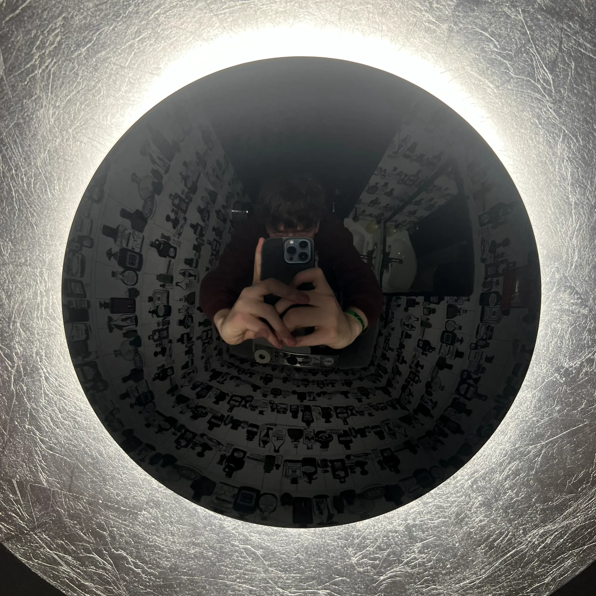 Nate's reflection in a round backlit mirror